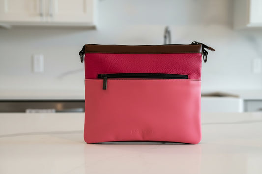 Pink handbag side 1 of 4 with a black zipper