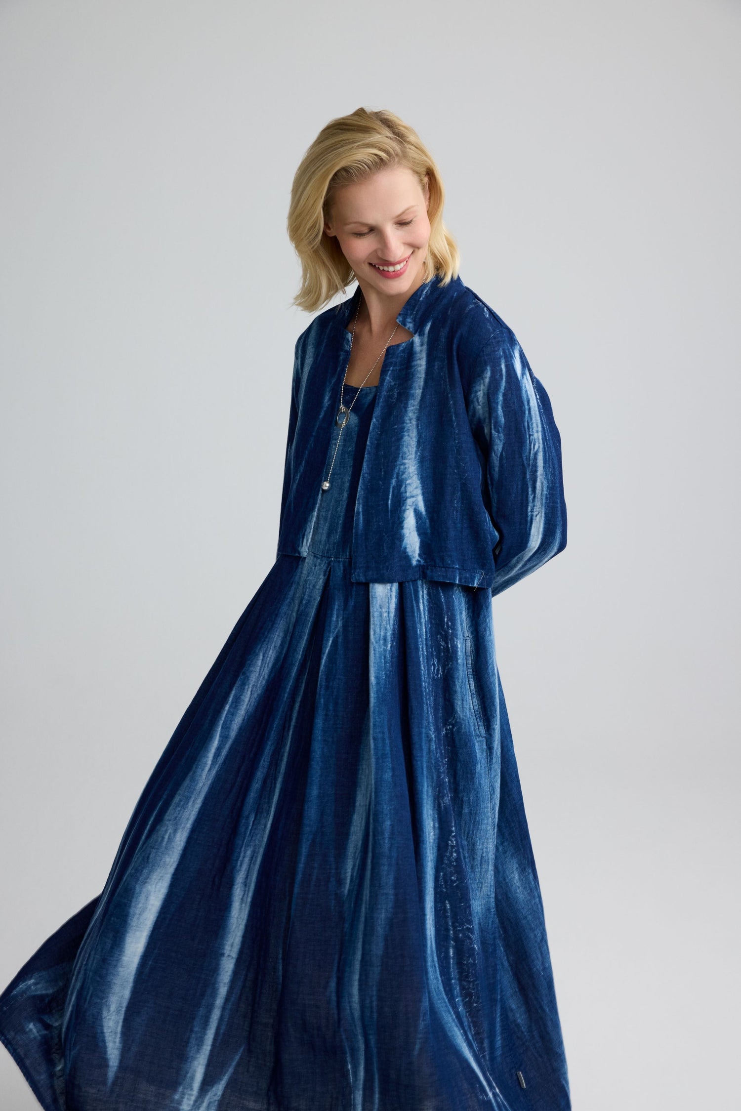 Woman wearing a blue Luukaa dress against a plain background