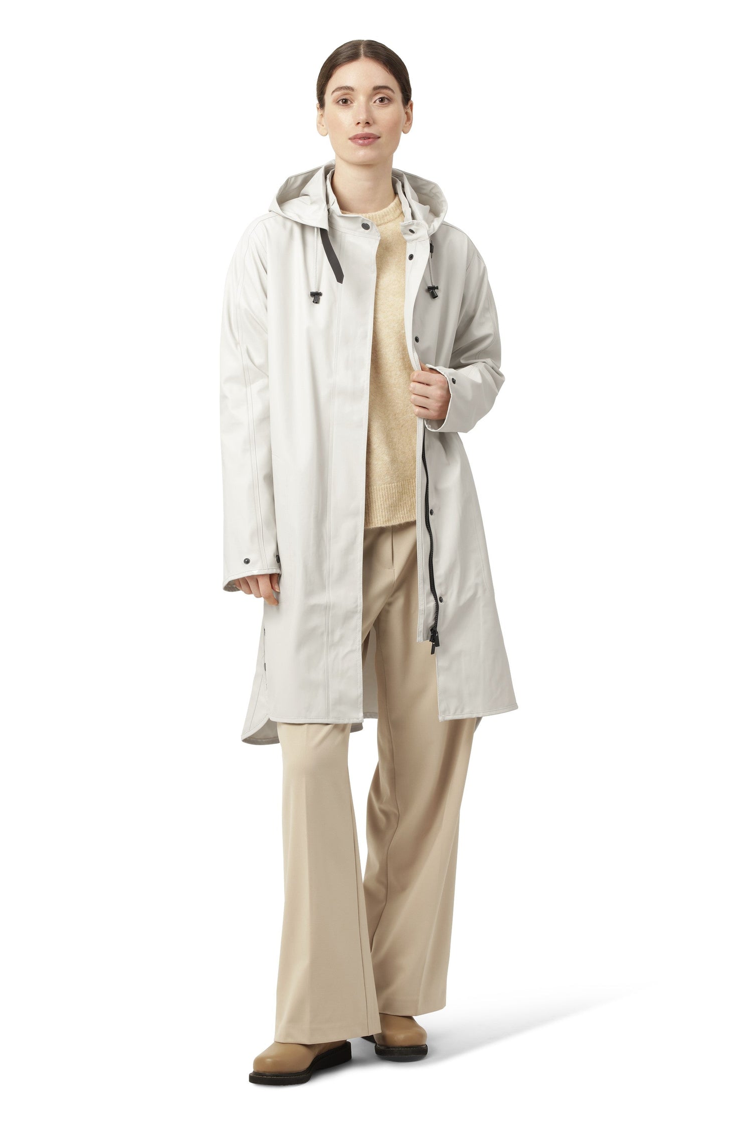 Model wearing off-white long rain coat by Ilse Jacobsen at Suttles & Seawinds in Mahone Bay, NS