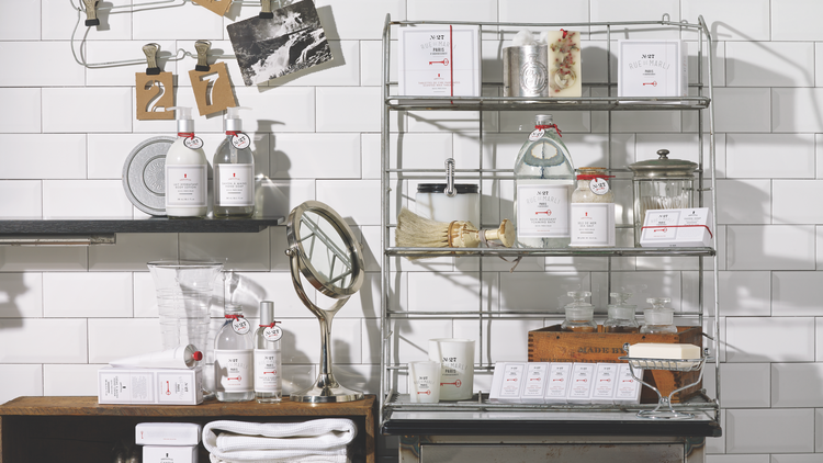 Rue de Marli N°27 Bois Précieux soaps, candles and bottles on an apothecary shelf