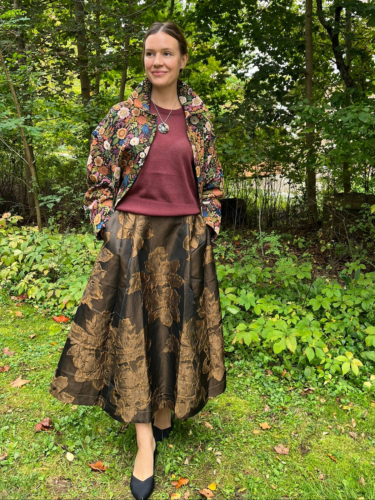 Cari wearing the Minus Meg jacket in black floral with the Minus Liva metallic pullover, Andie midi skirt and a Spring Moon labradorite pendant