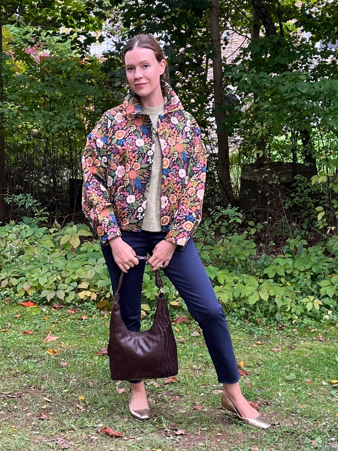 Cari wearing the Minus Meg jacket in black floral with the Minus Cheryl knit in fir green, FDJ Olivia slim ankle jeans and a Milo leather purse