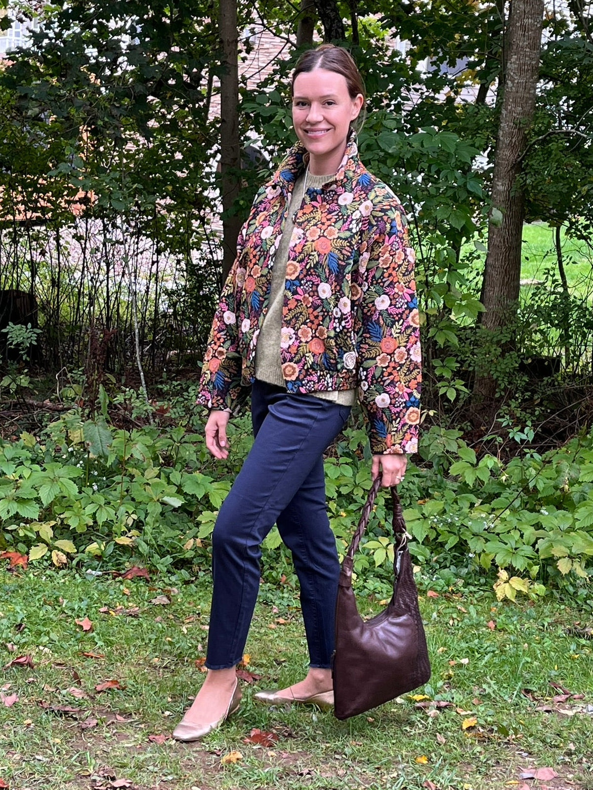 Cari wearing the Minus Meg jacket in black floral with the Minus Cheryl knit in fir green, FDJ Olivia slim ankle jeans and a Milo leather purse