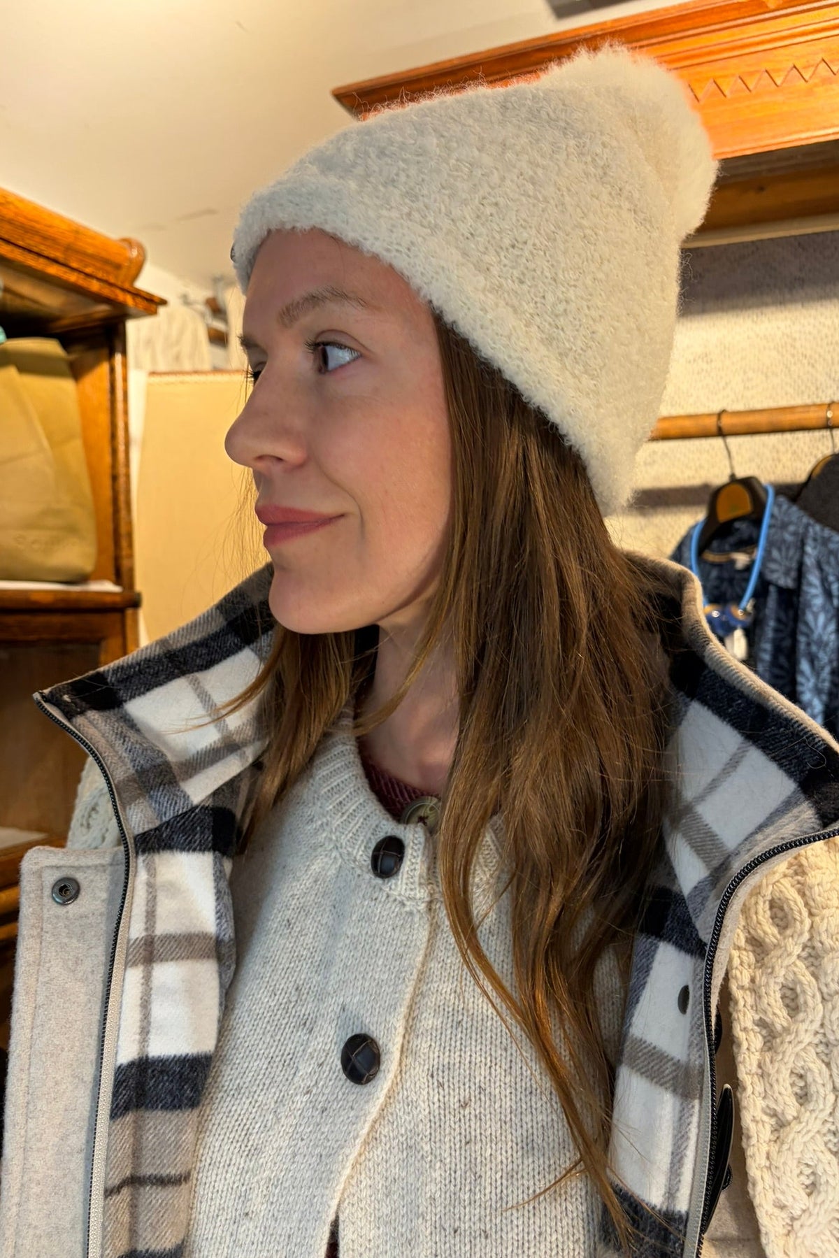 Cari wearing the Junge Sophie Duffel Coat over the Cassia cardigan and White Stuff Millie Cord Shift Dress, with teal tights, an alpaca pompom hat and the Mucros Fiona bag