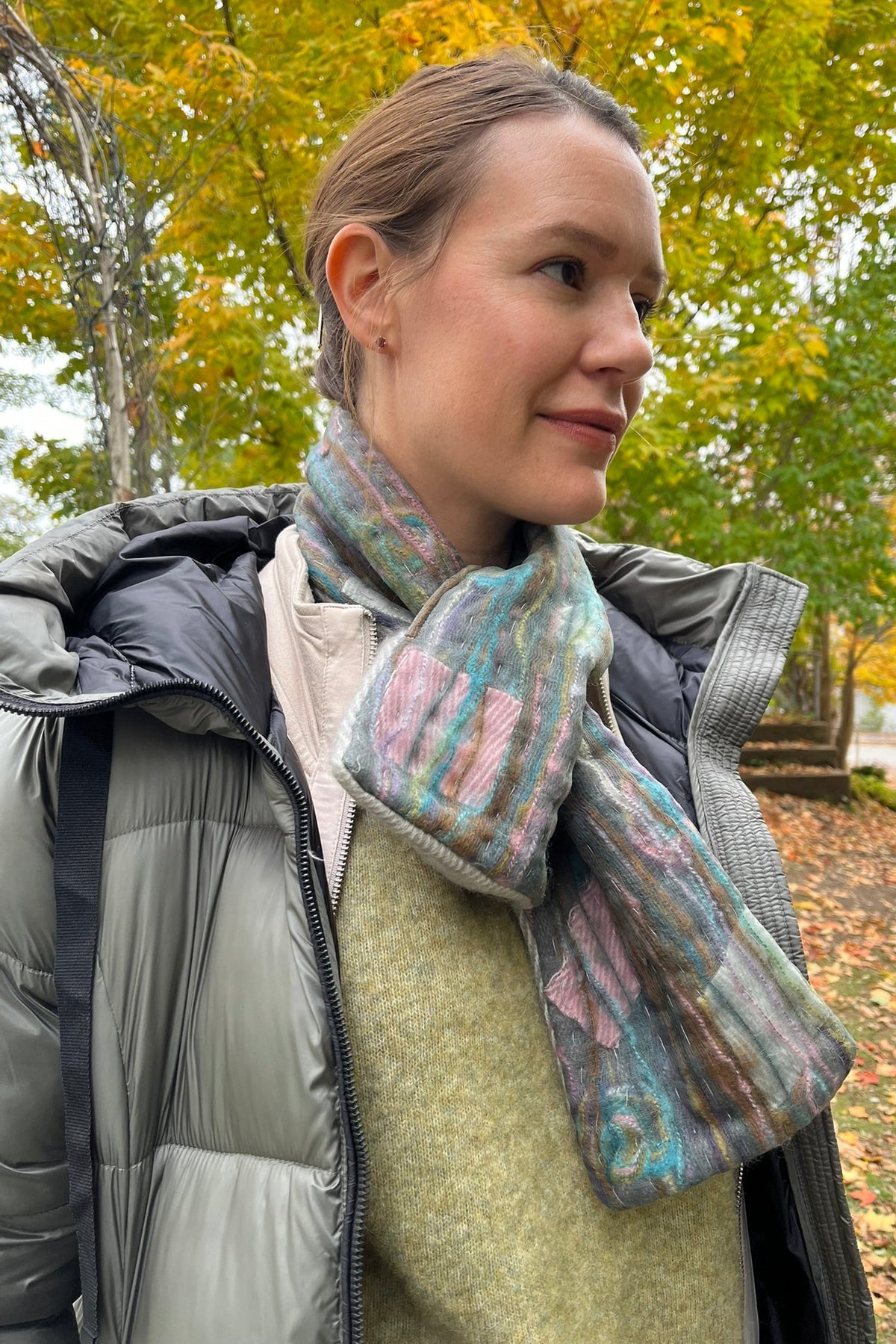 Cari wearing the Normann long hooded puffer coat in sage over a FOIL jacket, Minus Cheryl knit and FOIL Smooth Talker pants, with a Tresart silk muffler scarf and LUV & Co. gloves