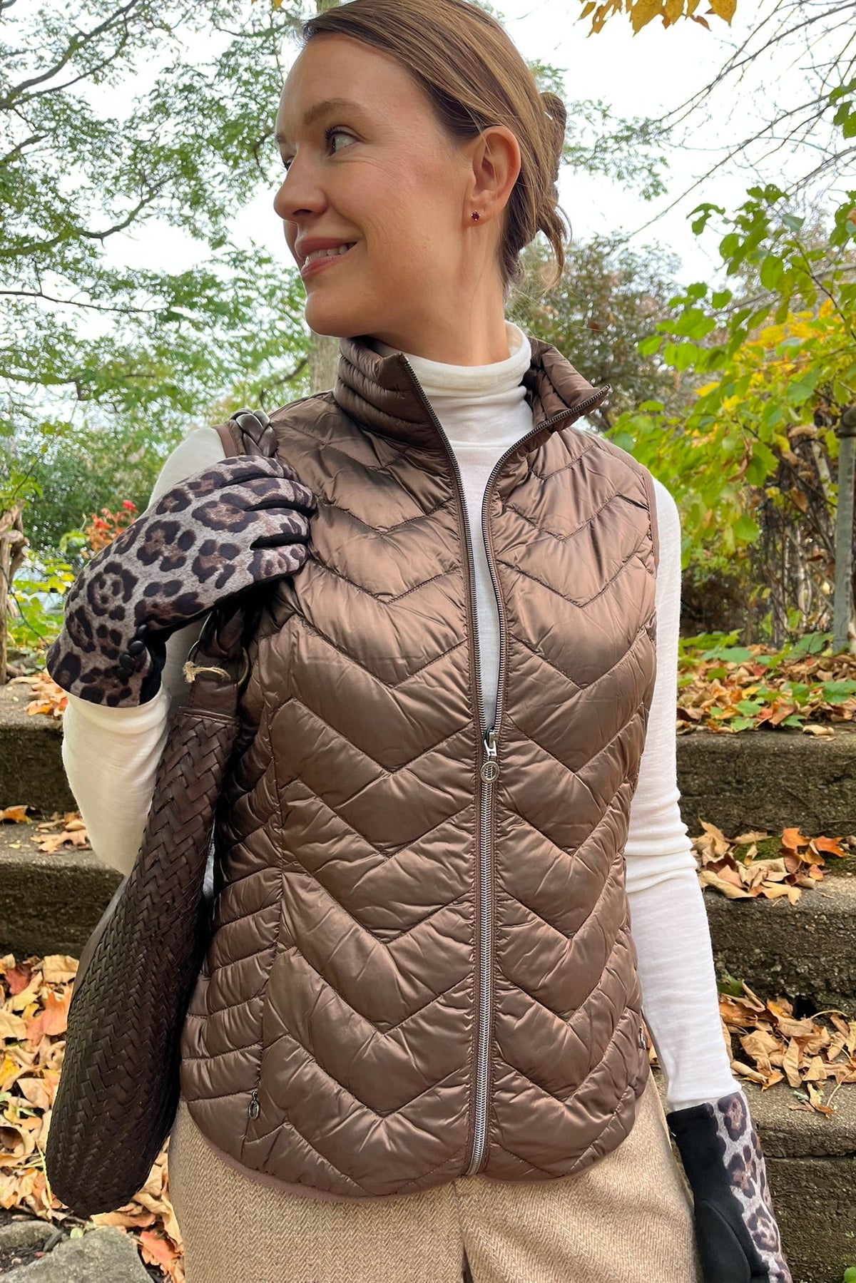 Cari wearing the Junge Louise down vest in brown over a Minus Cally roll neck and Wit & Wisdom Whitney trousers, with the Milo Albany bag and LUV & Co. leopard gloves