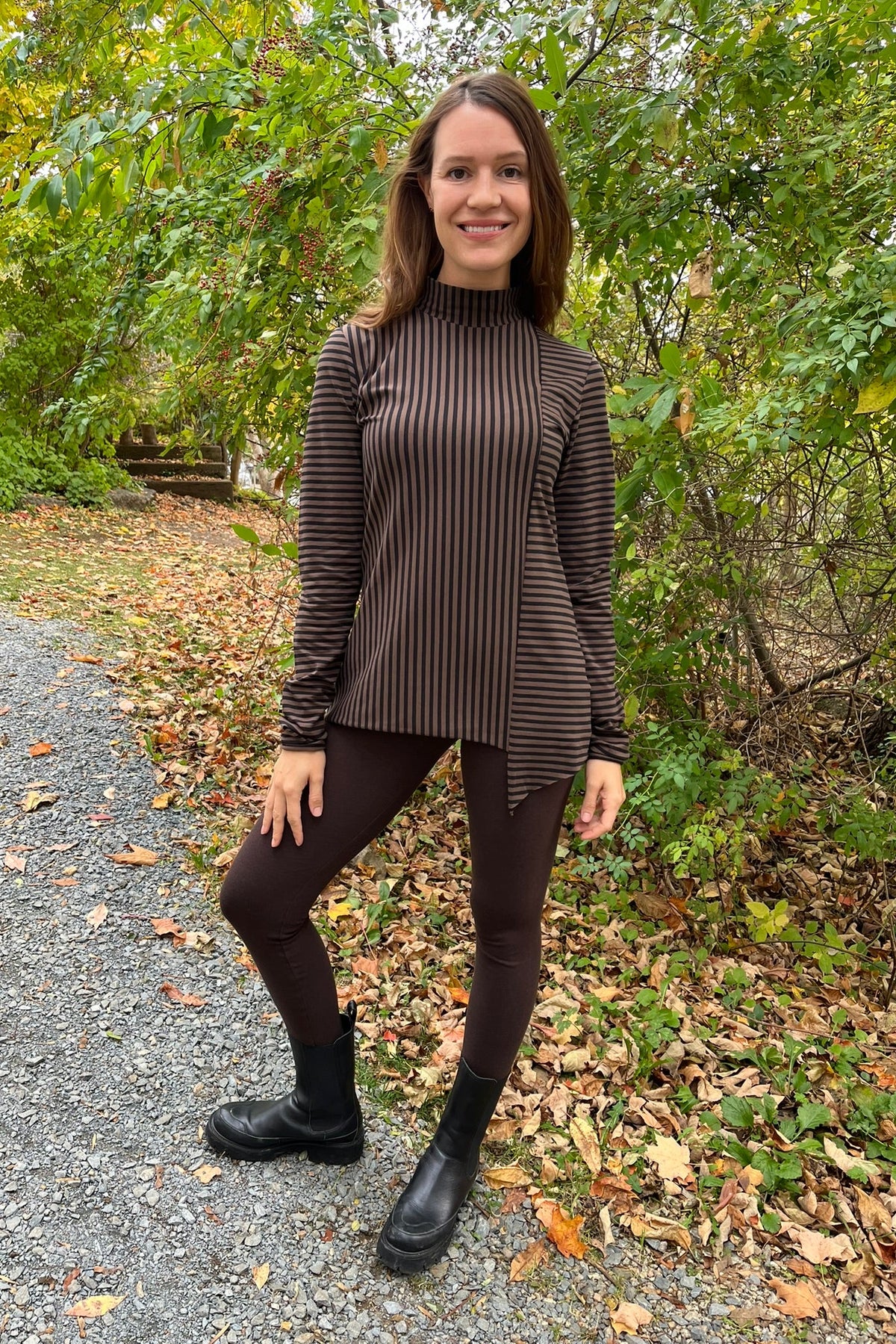 Cari wearing the Junge Phillipa down coat in brown over a Blue Sky Cortes jacket, LUUKAA stripe pullover and HUE leggings, with a Maison Izzy hooded scarf, alpaca pompom hat and LUV & Co. gloves