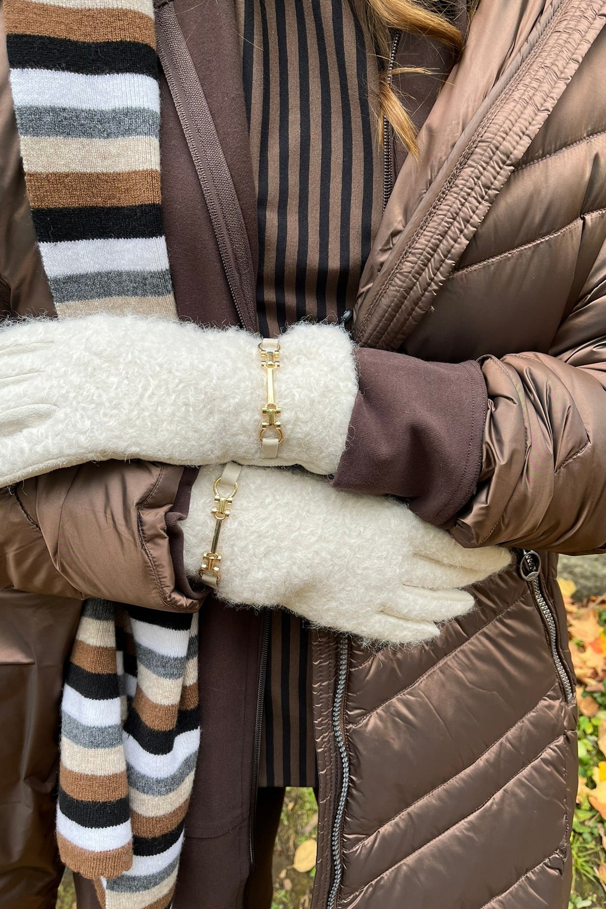 Cari wearing the Junge Phillipa down coat in brown over a Blue Sky Cortes jacket, LUUKAA stripe pullover and HUE leggings, with a Maison Izzy hooded scarf, alpaca pompom hat and LUV & Co. gloves