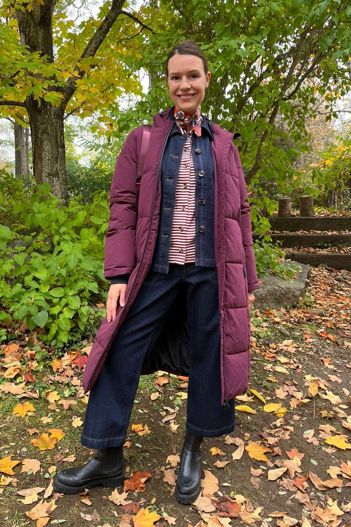 Cari wearing the Normann mid calf puffer in plum over a White Stuff Eden denim jacket, Imogen shirt and Tia jeans, with a Skyla crossbody bag and Lyla + Luxe skinny scarf