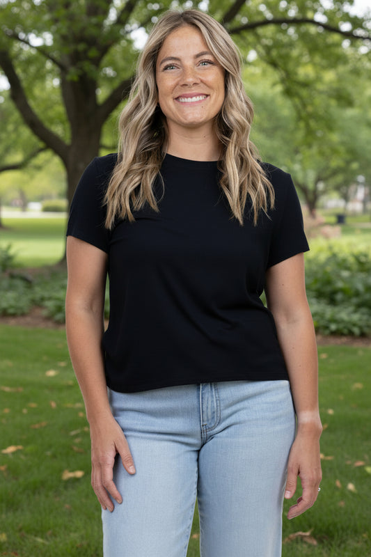 Woman wearing a black t-shirt and light blue jeans 