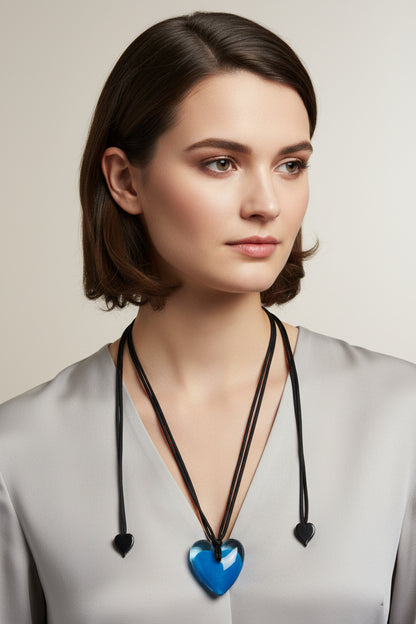 A blue heart-shaped pendant necklace on a black cord with heart-shaped attachments at each end.
