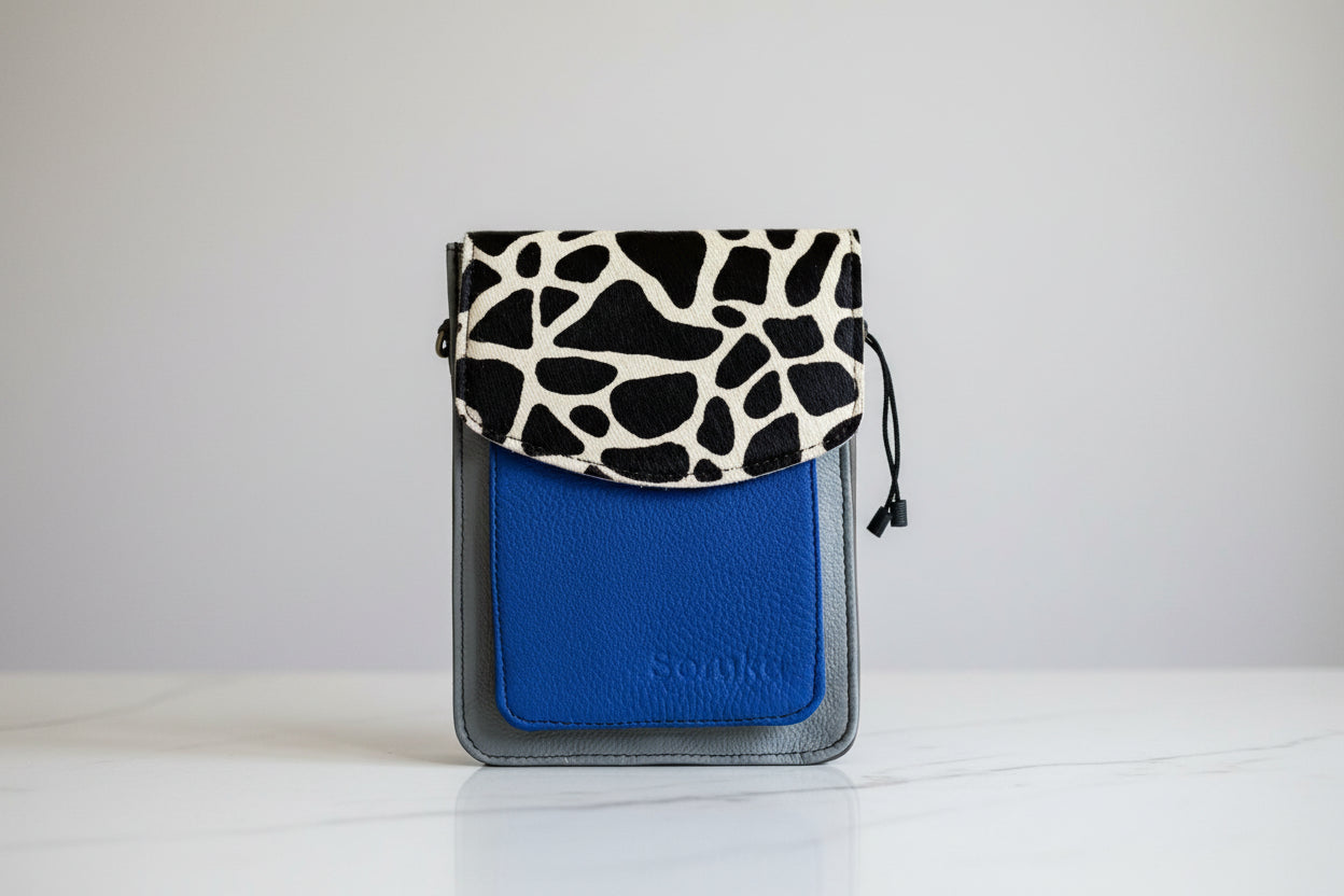 Blue handbag with giraffe patterned flap front face