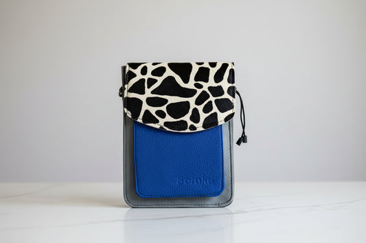 Blue handbag with giraffe patterned flap front face