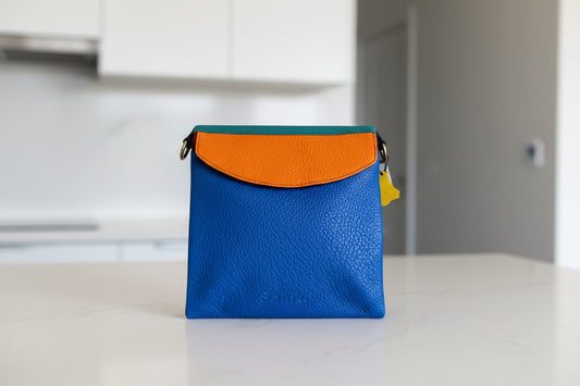 Blue leather handbag with orange flap side 1