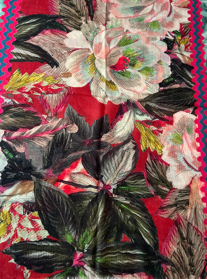 A square scarf with a vibrant red background, featuring large white and pink peony-style flowers, dark green leaves, and a colorful zigzag border in pink, teal, and red.