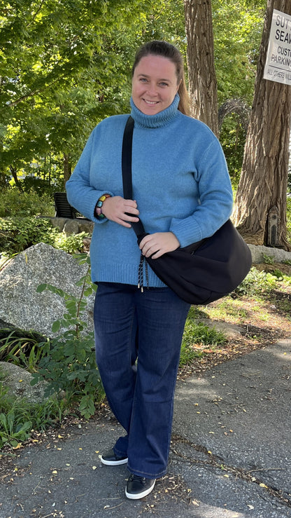 Alma wearing the Echo Verde Dog Walker cowl sweater in azure blue with Carreli baby boot jeans and a Skyla crossbody bag