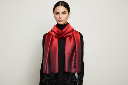 Red silk scarf with black tassels on a marble surface
