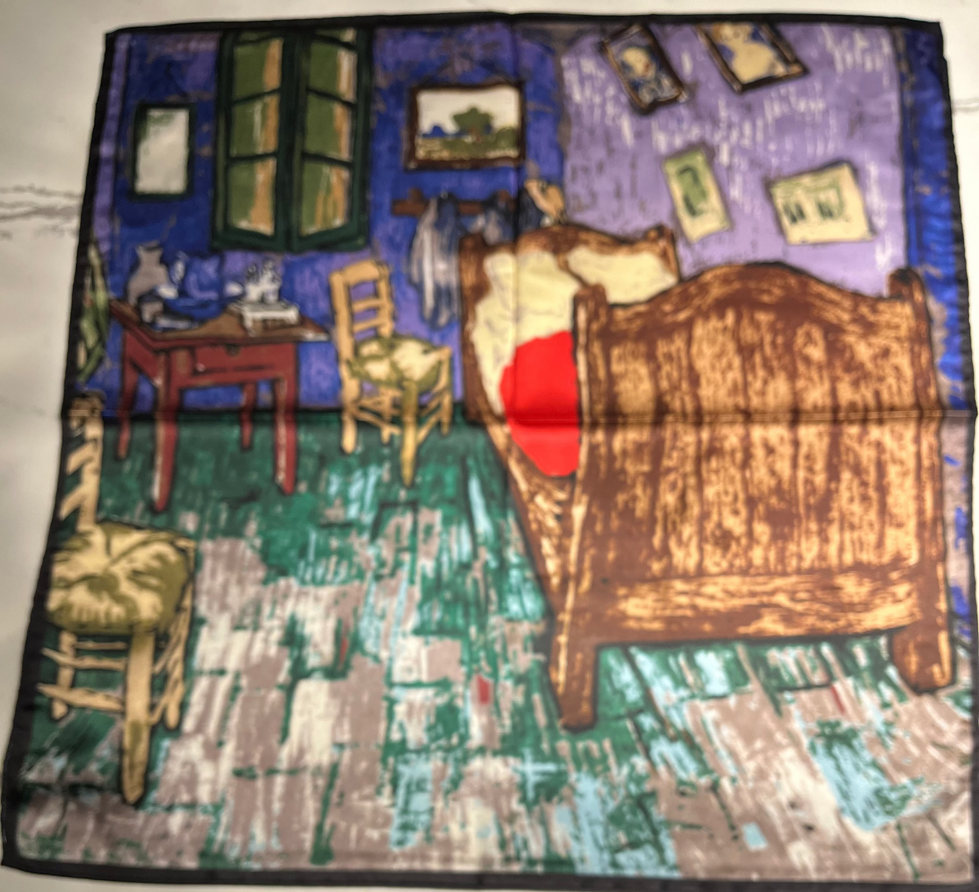 scarf with a printed design of a bedroom scene on a white surface.
