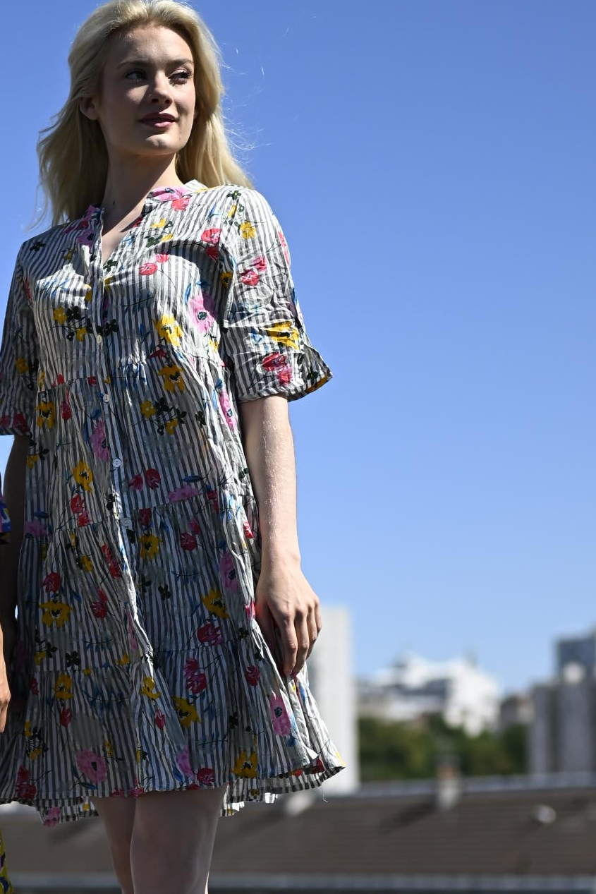 Woman wearing a floral dress against a clear blue sky