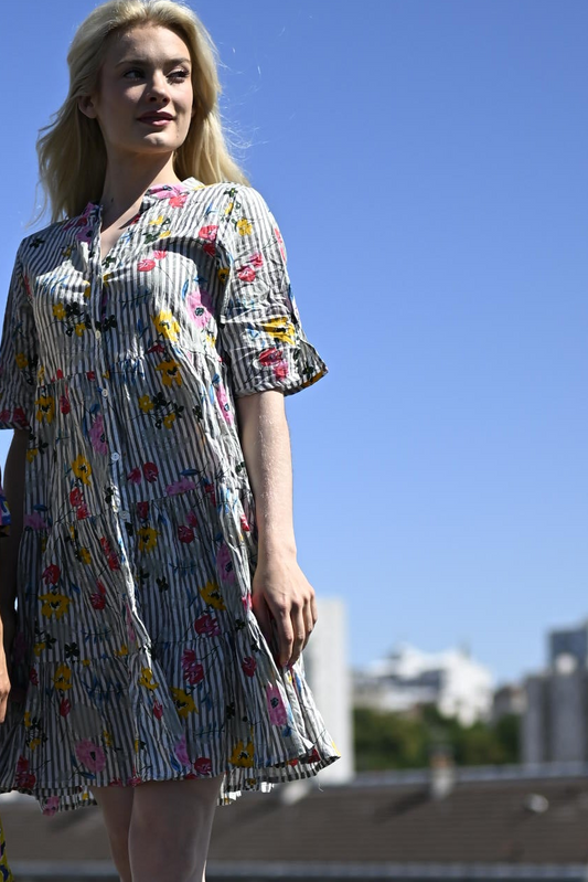 Woman wearing a floral dress against a clear blue sky