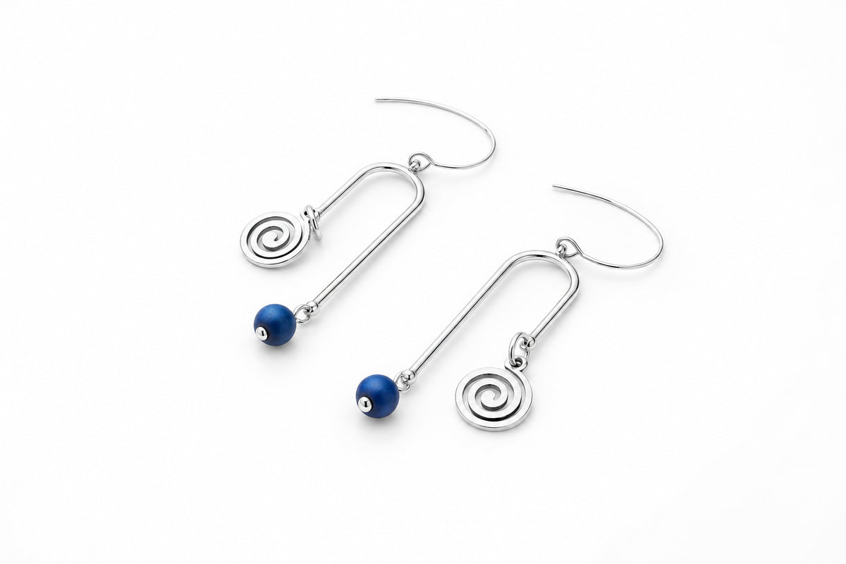 A pair of gold drop earrings with spiral charms and small dark blue beads, displayed on a clean white surface.