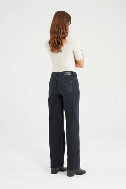 Person wearing dark jeans and a white top on a white background