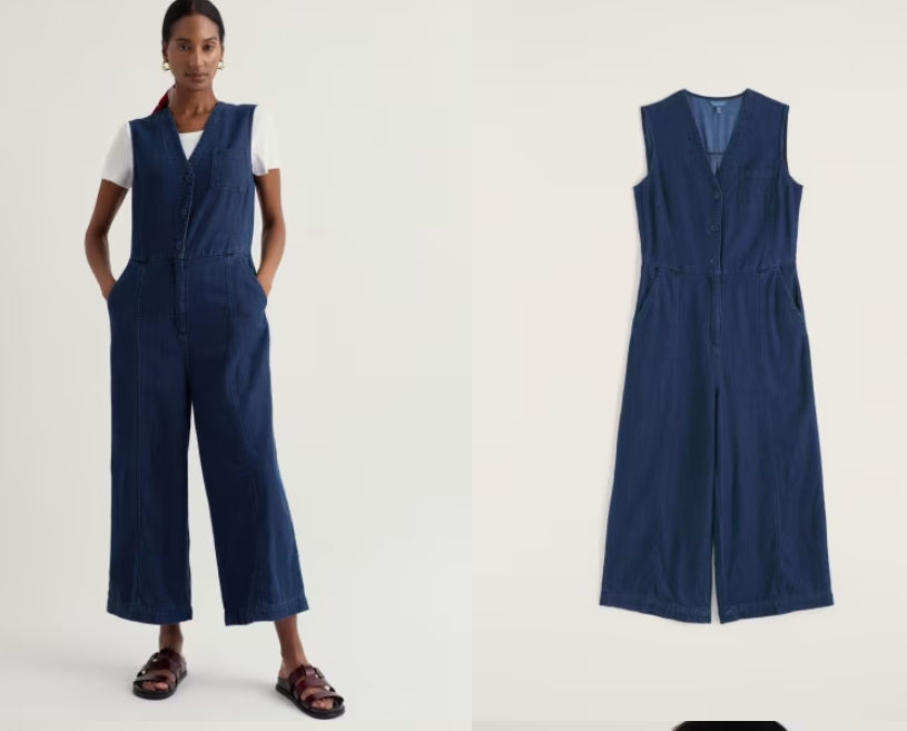 Woman wearing a navy blue jumpsuit with a plain white background