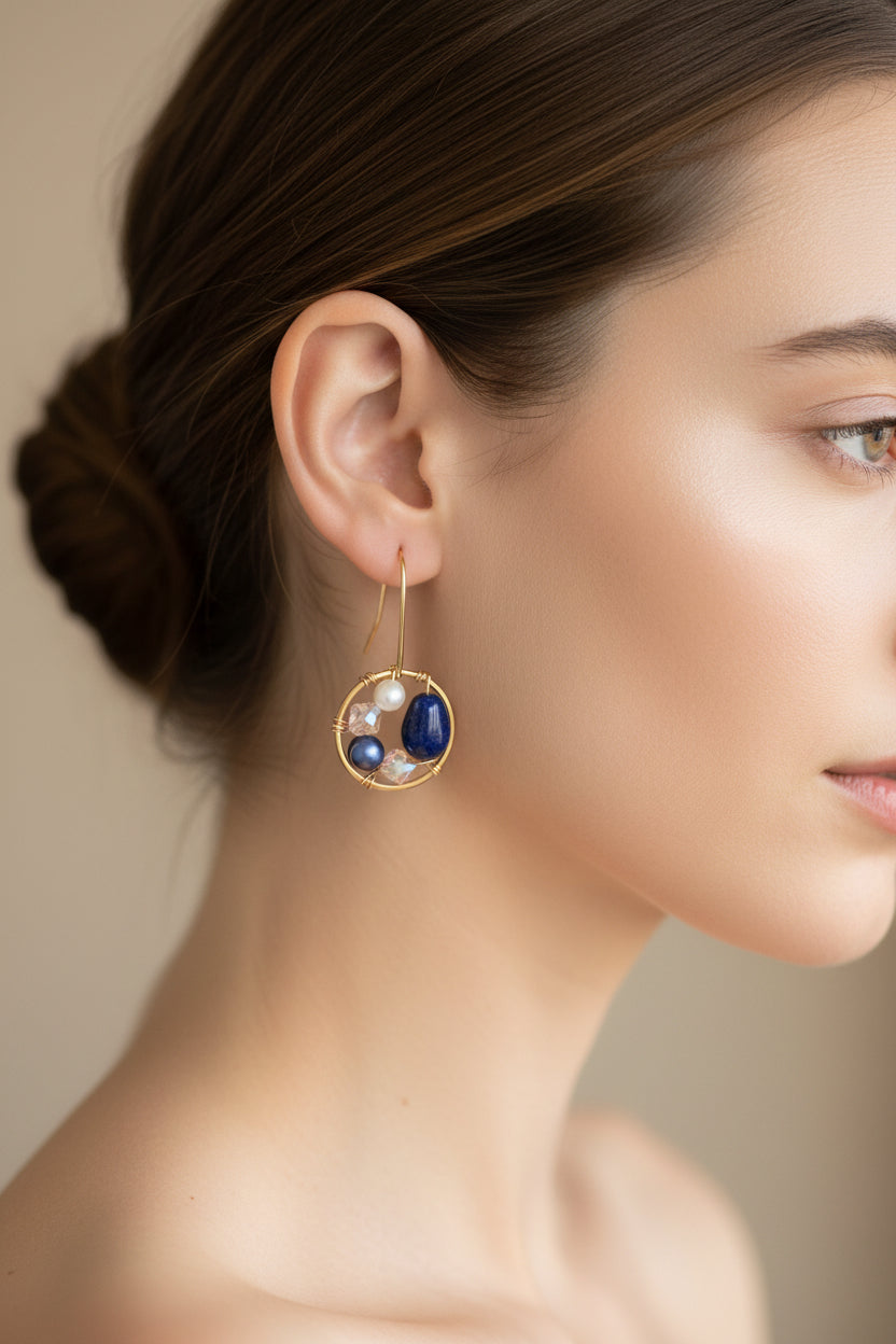 Pair of gold earrings with blue stones on a white background