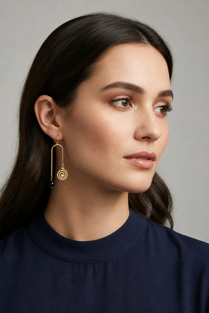Gold spiral earrings with blue beads on a white background