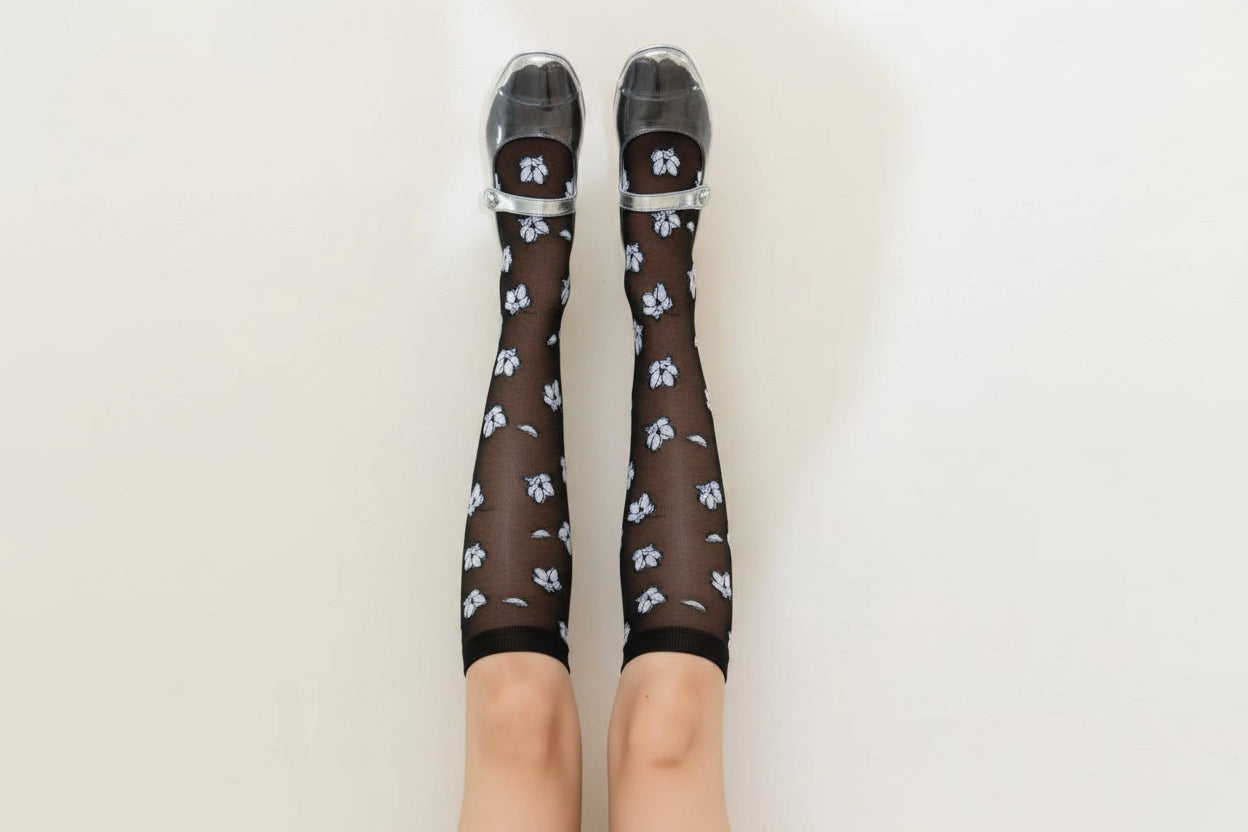 Brown knee-high socks with floral pattern and clear shoes on a beige background