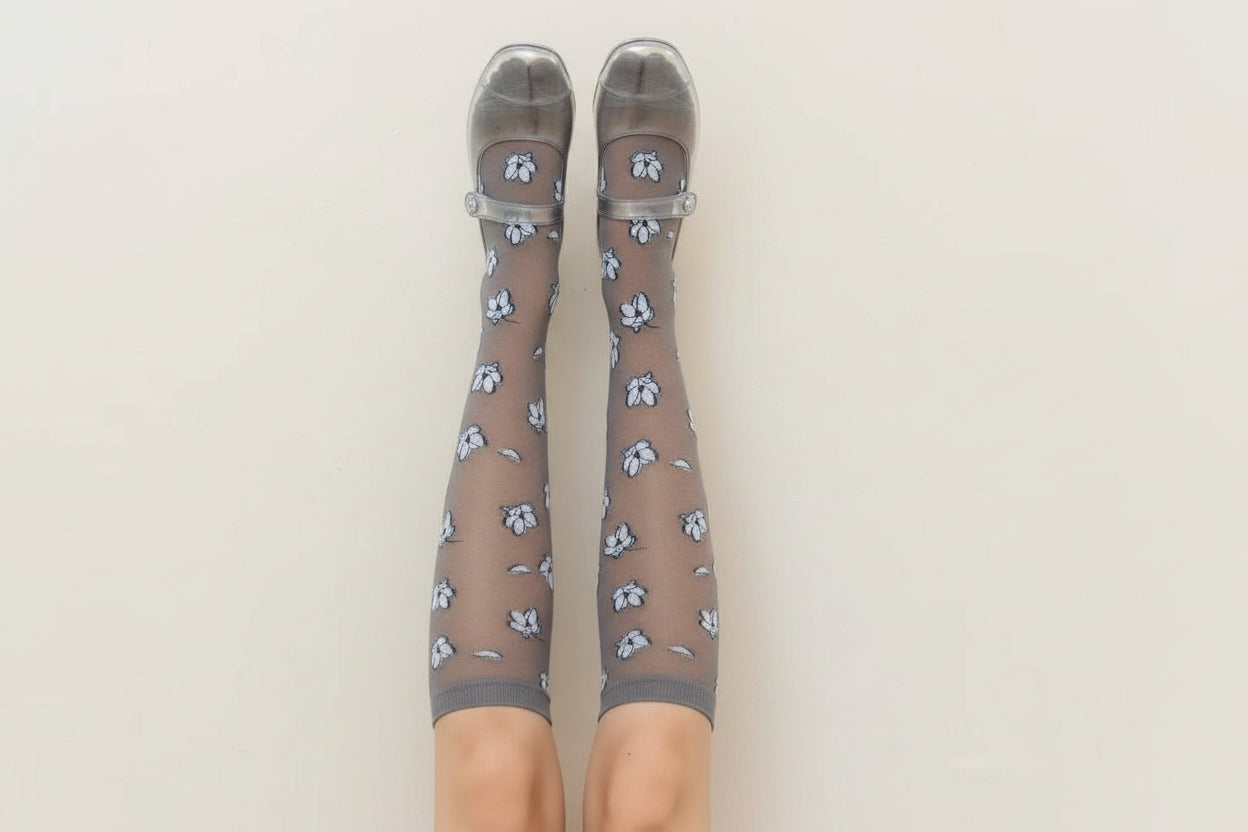 Brown knee-high socks with floral pattern and clear shoes on a beige background