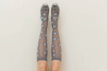 Brown knee-high socks with floral pattern and clear shoes on a beige background