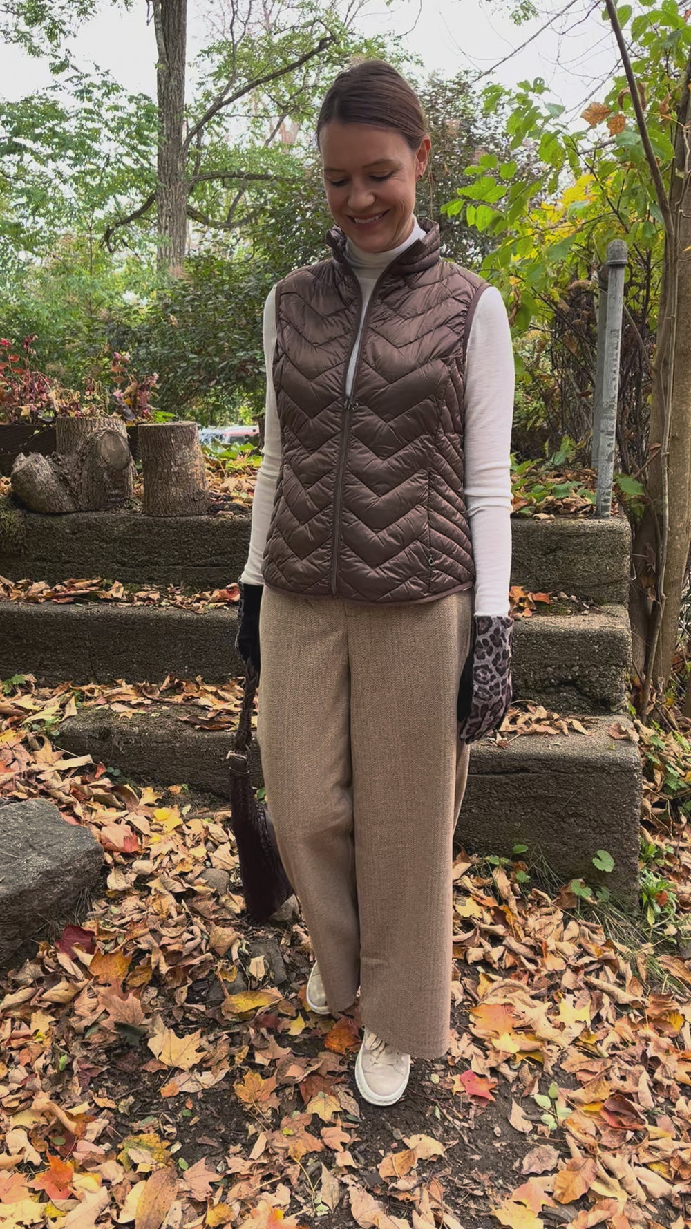 Cari wearing the Junge Louise down vest in brown over a Minus Cally roll neck and Wit & Wisdom Whitney trousers, with the Milo Albany bag and LUV & Co. leopard gloves